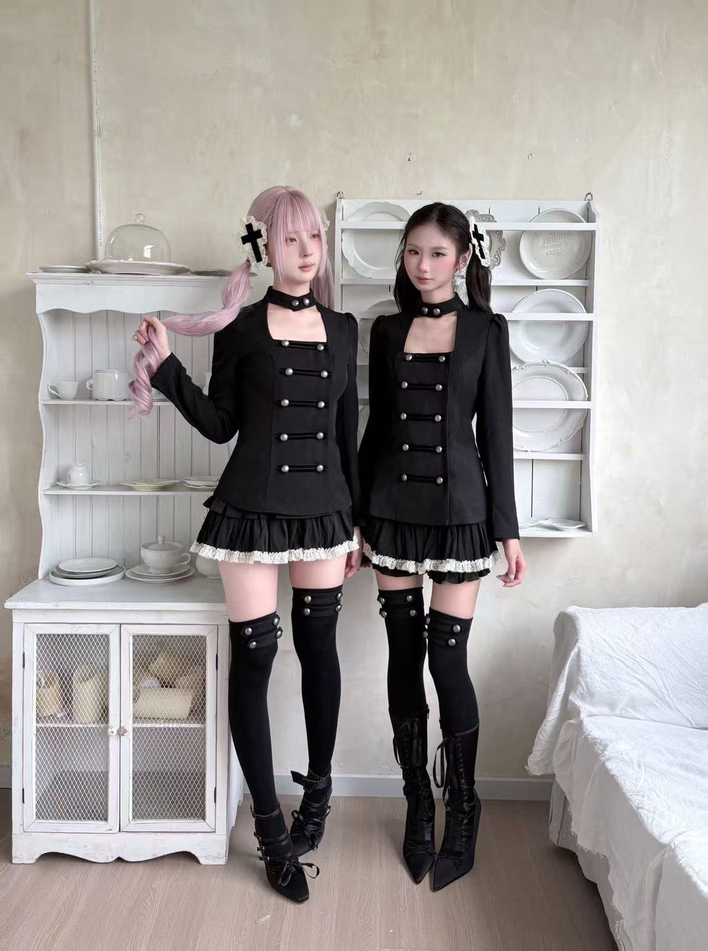 Two models wearing coordinated black gothic outfits
