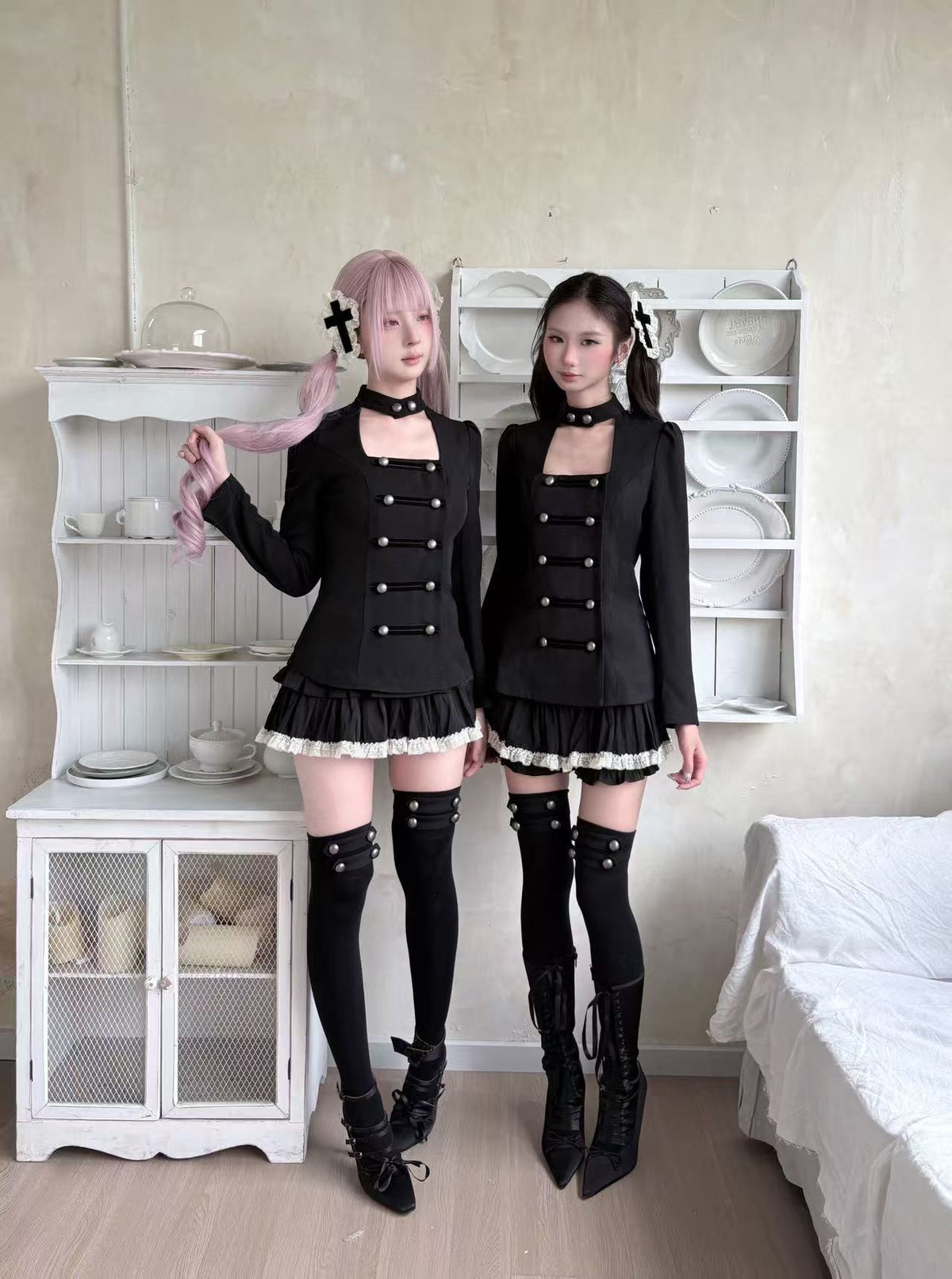 Two models wearing coordinated black gothic outfits